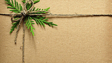 Karton mit Präsenten Karton mit Schleife und immergrünem Zweig