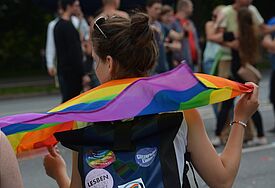 Kirche beim CSD: "Der Auftrag ist, das Leben als Ganzes zu ehren!" Frau mit Regenbogenflagge auf der Demo