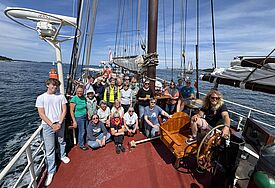 Reisen unter Segeln – Frauen erleben Nähe und Weite 24 Frauen und zwei Männer haben sich bei der Frauenegelreise auf dem Mittelschiff des Traditionsseglers Regina Maris für ein Foto versammelt.