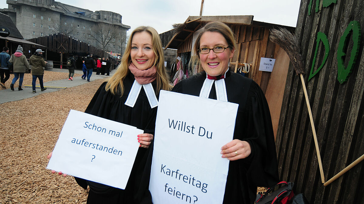 Die Vikarinnen Anna Cornelius (l.) und Tia Pelz machen da Kirche, wo die Menschen sind: Auf dem Hamburger Dom sprechen sie mit den Besuchern über Ostern.