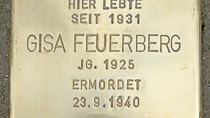 Eine quadratische Bodenplatte aus Messing mit der eingestanzten Inschrift: Hier lebte seit 1932 Gisa Feuerberg Jg. 1926 ermordet 23.9.1940 