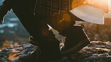 Hockender Mensch im Sonnenaufgang