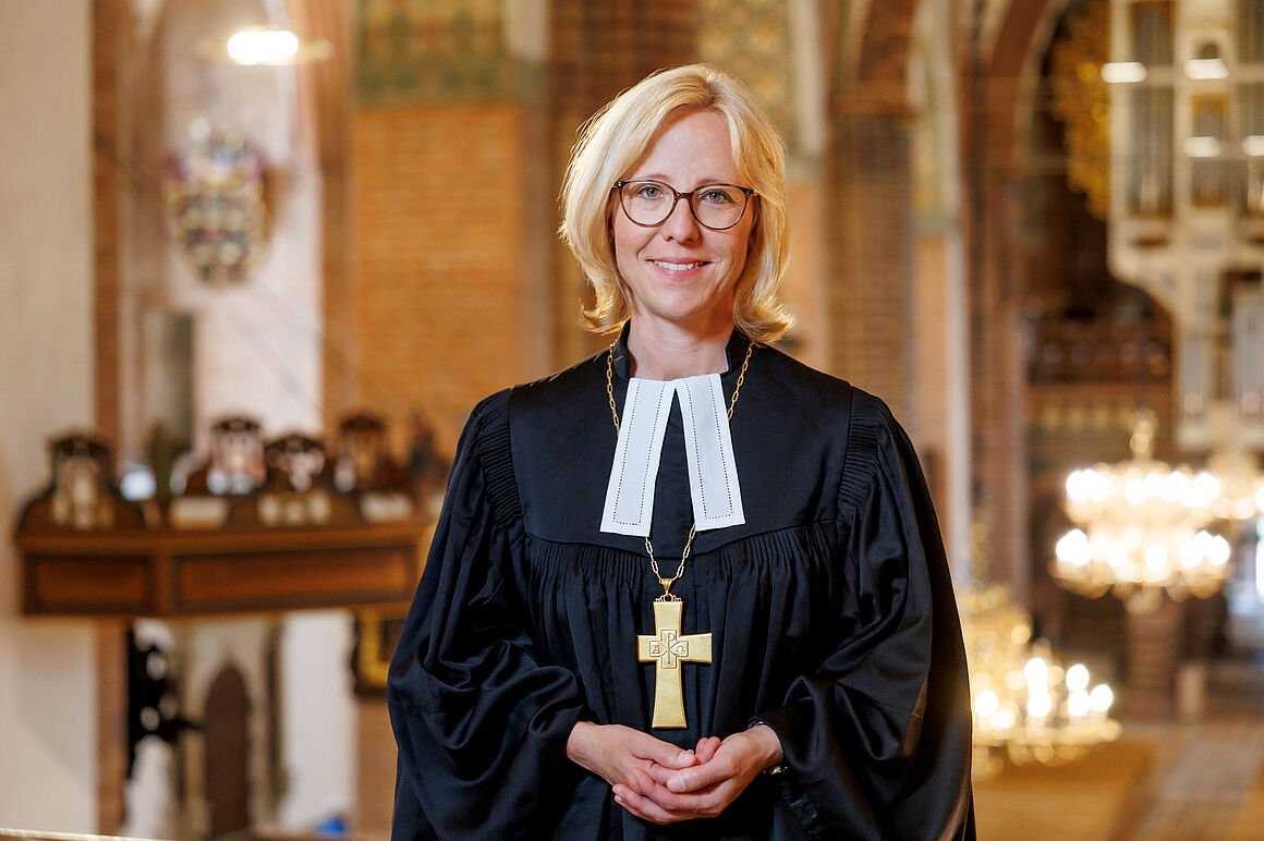 Bischöfin Nora Steen im Talar mit Blick in das Hauptschiff des Schleswiger Domes, 2024