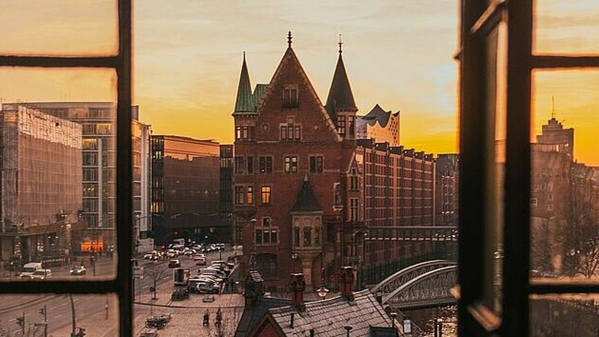 Blick auf die Hamburger Speicherstadt durch ein geöffnetes Fenster.