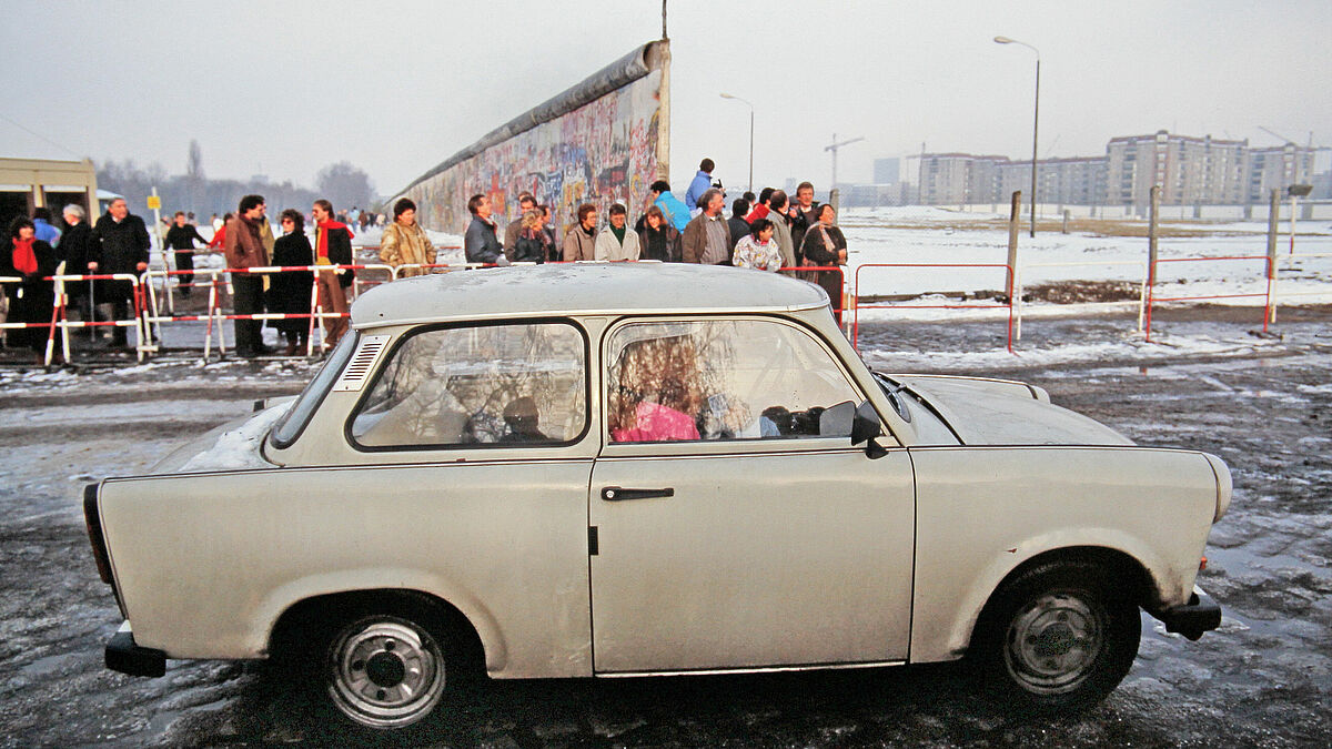 Berliner Mauer nach der Öffnung am Potsdamer Platz, ein Trabant ist nach einer Fahrt in den Westen auf dem Weg zurück nach Ost-Berlin. November 1989.