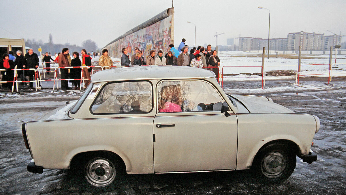 Berliner Mauer nach der Öffnung am Potsdamer Platz, ein Trabant ist nach einer Fahrt in den Westen auf dem Weg zurück nach Ost-Berlin. November 1989.