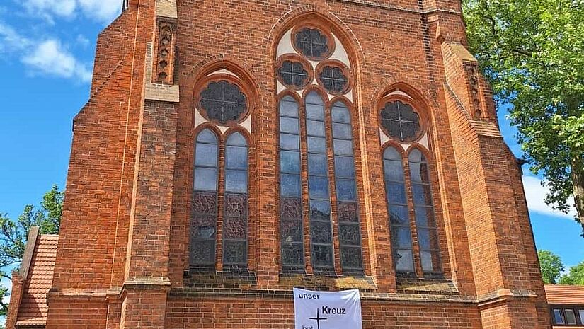An der Fassade der St. Johannis-Kirche Neubrandenburg hängt vor der Europawahl ein Plakat mit der Aufschrift "Unser Kreuz hat keine Haken"