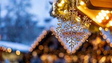 Lichter glänzen auf einem Weihnachtsmarkt.