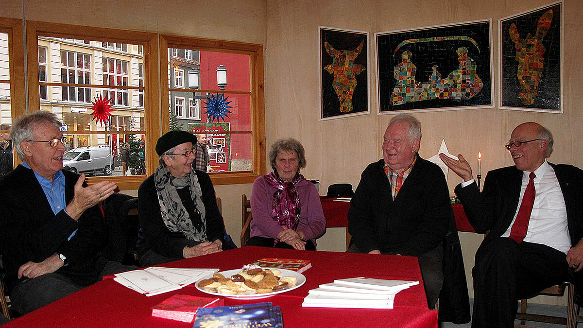 Landesbischof Gerhard Ulrich (r.) informierte sich im Gespräch mit den Ehrenamtlichen von Kapellenverein und Bürgerhafen über deren Engagement auf dem Weihnachtsmarkt