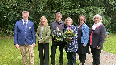 Sechs Personen stehen nebeneinander auf einer grünen Rasenfläche. Im Hintergrund stehen Bäume im vollen Laub. Die Personen von links nach rechts sind Synodenpräses Professor Dr. Stefan Krüger, Nora Steen, Bischöfin des Sprengels Schleswig und Holstein, Mathias Lenz, Inken Wöhlbrand, Dr. Christine Weide und die stellvertretenden Synodenpräses Heinke Mahrt.