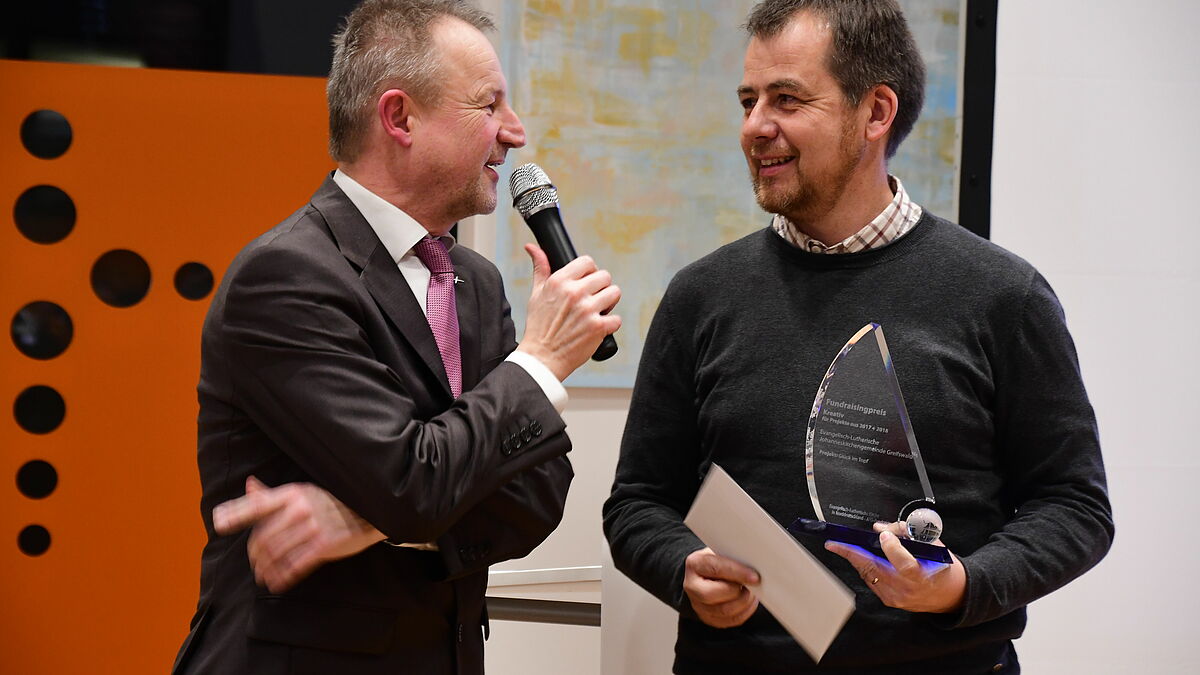 KLaus Struve (l.) interviewt Pastor Torsten Kiefer, der den Fundraisingpreis für das Projekt "Glück im Topf" entgegen nimmt.