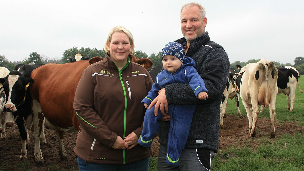 Annika und Christoph Jacobsen mit Sohn Jonne auf der Kuhweide.  