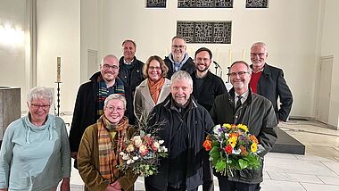 Die Überraschung ist gelungen: Mitten in einer Chorprobe erfuhr Peter Wolff (Mitte) von Pröpstin Petra Kallies, seinen Gemeindepastoren und Kirchengemeinderats- Mitgliedern, dass er zum Kirchenmusikdirektor ernannt wird.