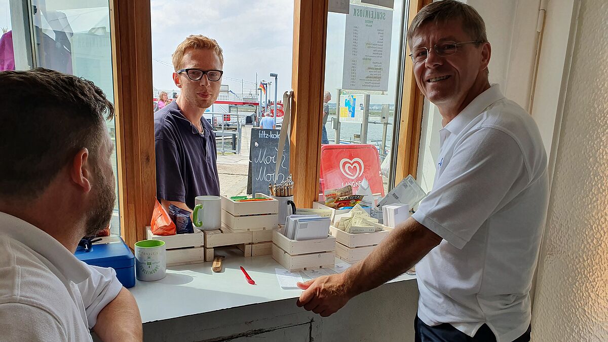 Diakonie-Vorstand Heiko Naß (r.) hilft im Kiosk der Giftbude auf der Lotseninsel an der Schleimündung.