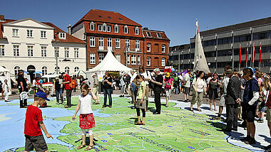 Kinder Spielen beim Gründungsfest auf Karte mit Gebiet der Nordkirche 