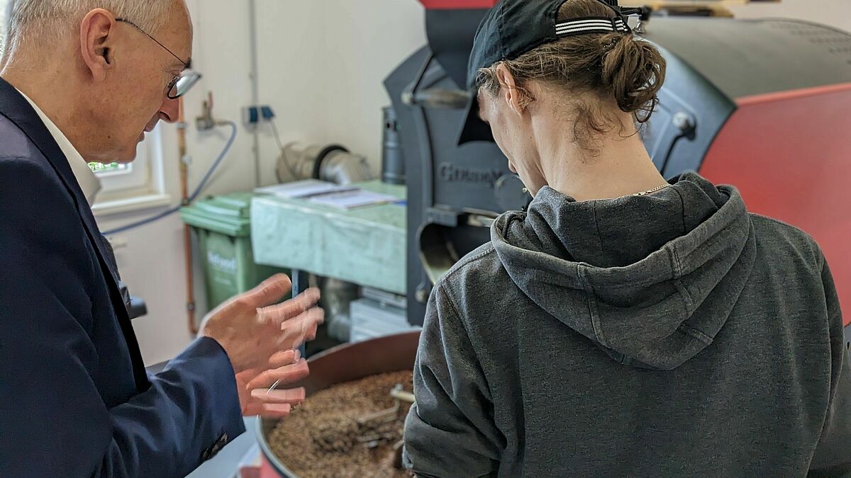 Landespastor Paul Philipps informiert sich in der Kaffeerösterei des Lebenshilfwerks Mölln-Hagenow über die Arbeit eines Werkstattrates. 
 