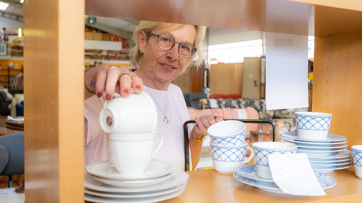 Rita Schneider platziert ein gespendetes Kaffeeservice im Sozialkaufhaus in Ahrensburg.