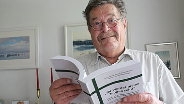 Manfred Kamper hält in der Hand die Neuausgabe der Breklumer Hefte