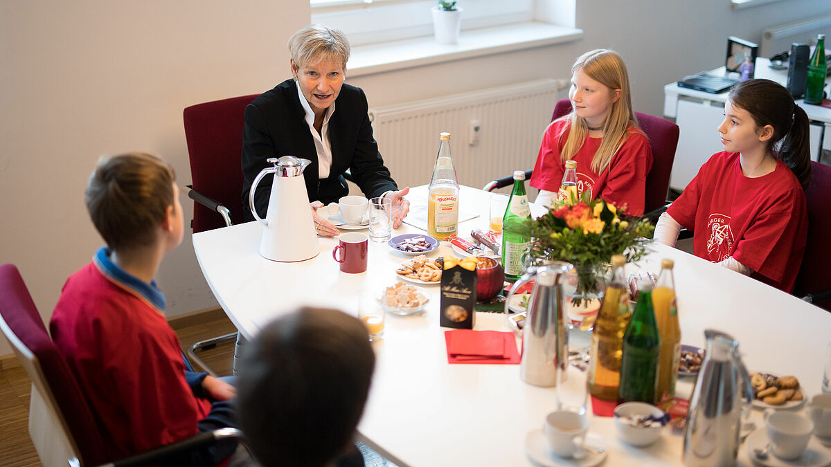 Bei Orangensaft und Schokolade diskutieren die Kinderbischöfe mit Bischöfin Kirsten Fehrs.