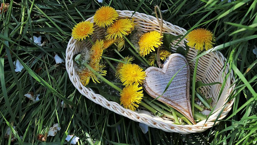 Korb mit Blumen und einem Holzherz