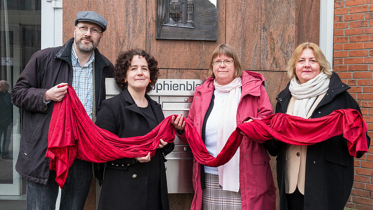  Die Gedenktafel für die Familie Posner wird feierlich enthüllt von (v. links): Walter Joshua Pannbacker von der Jüdischen Gemeinde Kiel, Künstlerin Ute Diez, Pröpstin Almut Witt, Stadtpräsidentin Bettina Aust.