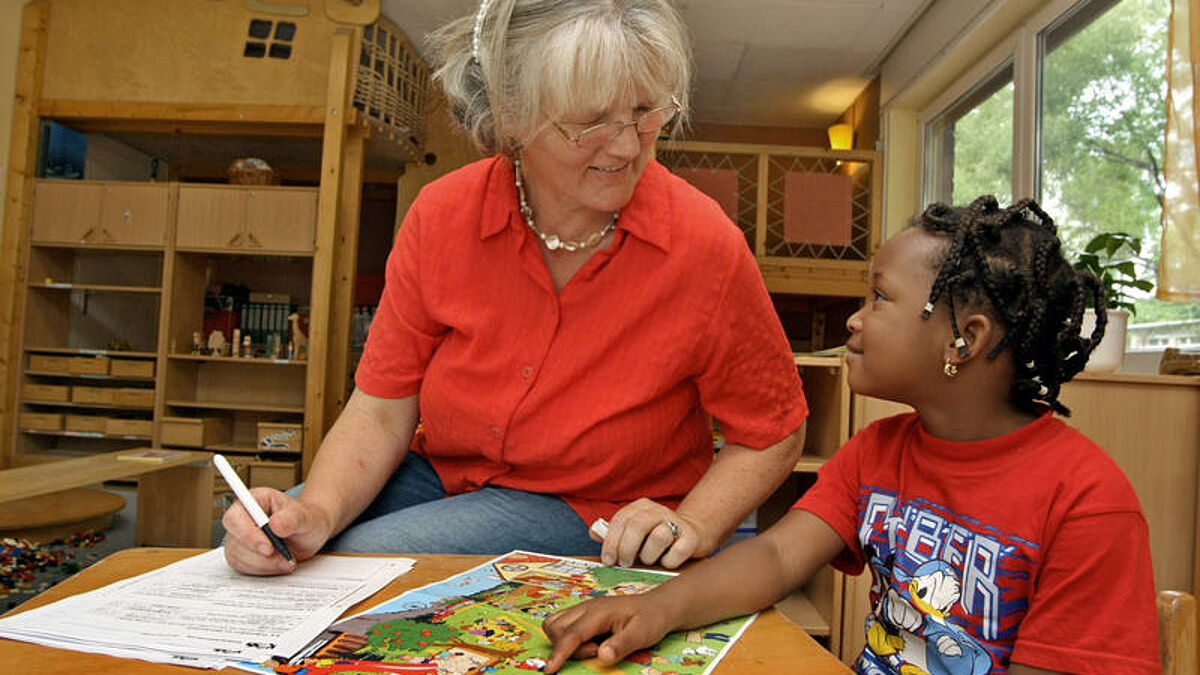 In einer evangelischen Kita: Eine Erzieherin beim Sprachtest mit Kindern (Symbolbild)