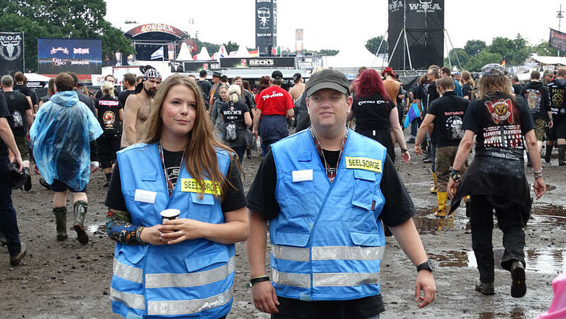 Heavy Metal, Schlamm und tröstende Worte: Pastorin Katharina Schunck macht mit ihrem Festivalseelsorge-Kollegen Fabian Schmidt einen Gang über das Festivalgelände in Wacken.