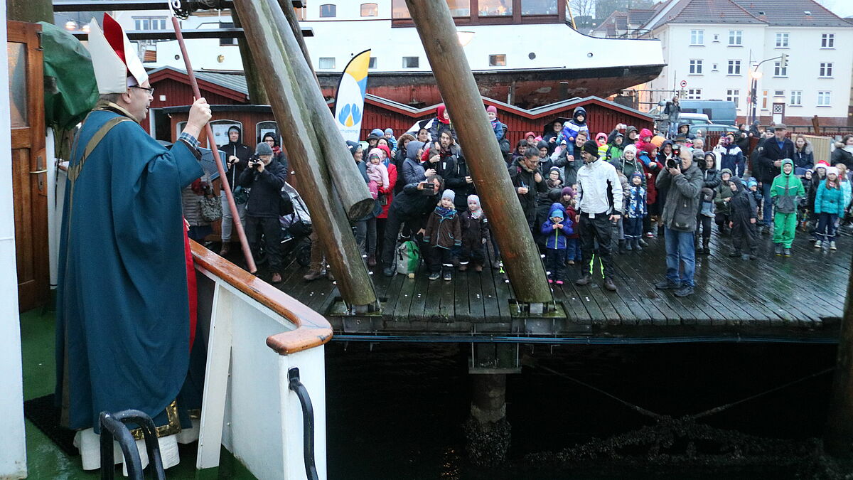 Der Nikolaus, der Bischof Gothart Magaard sehr ähnlich sieht, begrüßt die kleinen und großen Kinder in Flensburg.