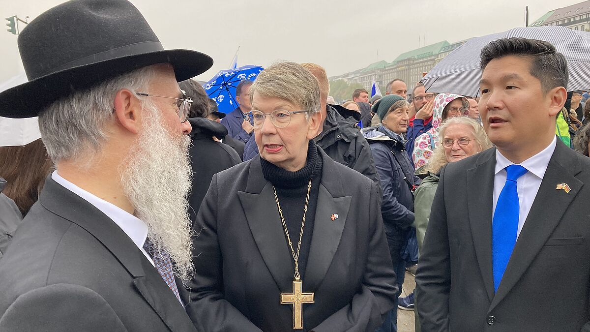 Landesbischöfin Kristina Kühnbaum-Schmidt mit Landesrabbiner Shlomo Bistritzky und den US-Generalkonsul Jason Chue auf der Kundgebung in Hamburg.