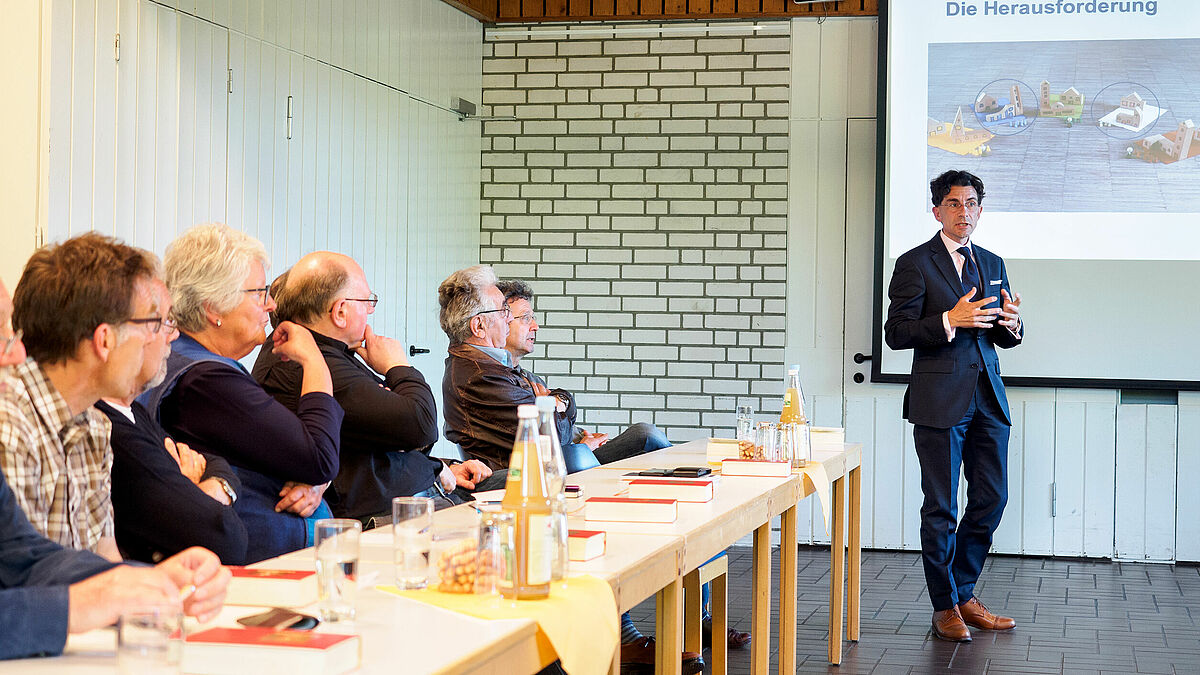 Christian Kuhlmann (r.) erläutert auf dem Info-Abend verschiedene Modelle, wie Kirchengemeinden zusammenarbeiten können.