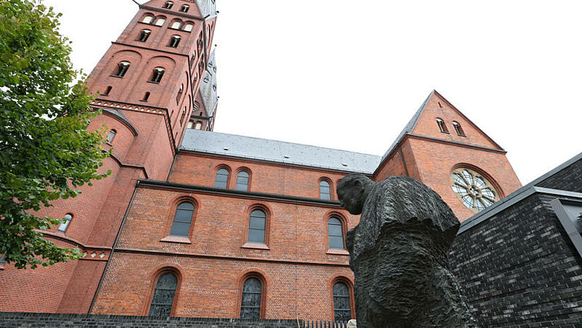 Blick auf den Hamburger Mariendom mit einem lebensgroßen Bronze-Denkmal für Papst Johannes Paul II., davon dem Künstlers Jozek Nowak 2007 geschaffen worden war. 