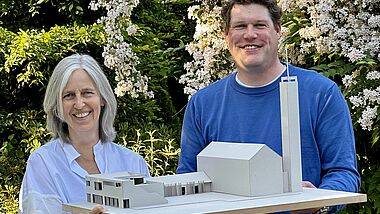 Bettina Wache-Möhle, Vorsitzende im Kirchengemeinderat, und Pastor Matti Schindehütte, mit einem Modell des neuen Gemeindehauses in Großhansdorf.