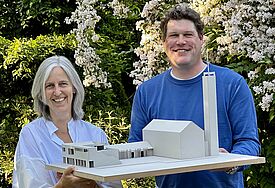 Bettina Wache-Möhle, Vorsitzende im Kirchengemeinderat, und Pastor Matti Schindehütte, mit einem Modell des neuen Gemeindehauses in Großhansdorf.