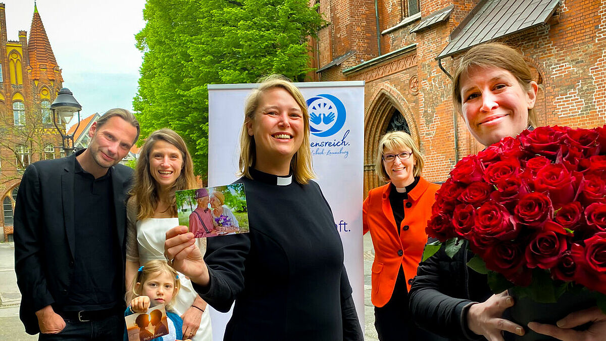 Brautpaar, Blumenkind und rote Rosen: Sarah Stützinger, Inga Meißner und Frauke Eiben waren unter anderem in Lübeck unterwegs, um mit Menschen zum Thema Segen ins Gespräch zu kommen.