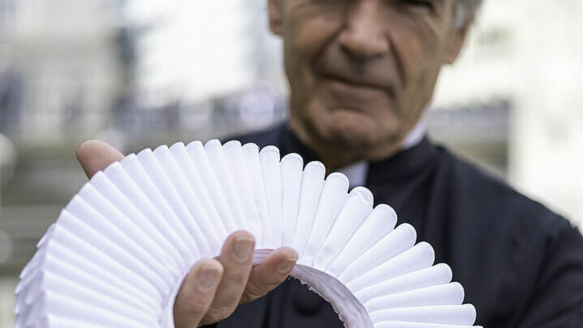 Pastor Bernd Lohse hält seine Halskrause in die Kamera. In Hamburg gibt es zwischen 60 und 70 Pastorinnen und Pastoren, die noch die traditionelle Halskrause tragen. 