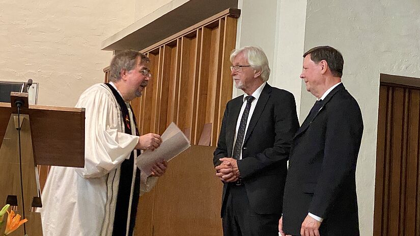 Uwe Onnen, Vorsitzender der ACK Hamburg, übergibt Urkunden an Mitglieder der Neuapostolischen Kirche Nord- und Ostdeutschland zur Aufnahme