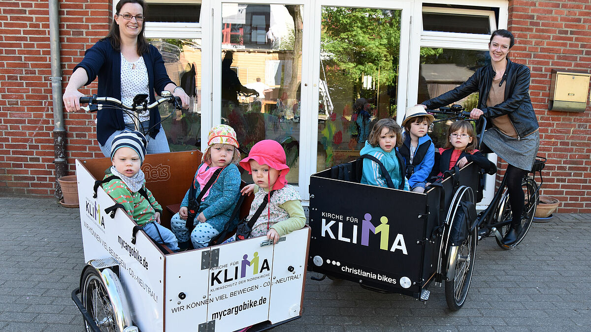 Kitaleiterin Claudia Wagner (l.) und Klimaschutzmanagerin Klaudia Morkramer (r.) mit den Elektro-Rädern des Umwelt- und Klimaschutzbüros der Nordkirche vor der Kita Paulus Altona.