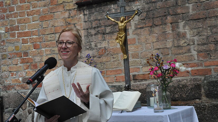 Bischöfin Nora Steen predigt an Christi Himmelfahrt bei einem Gottesdienst auf dem Hof der St. Marienkirche in Flensburg.