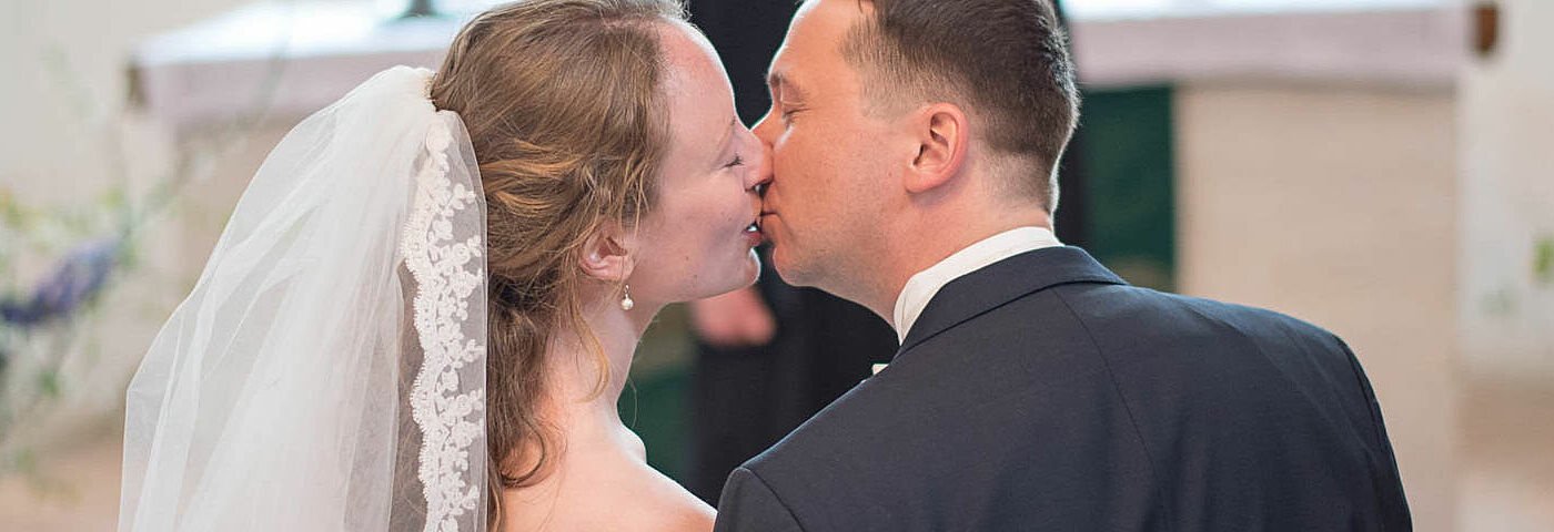 Ein Hochzeitspaar küsst sich bei seiner Trauung in der Belliner Kirche in Mecklenburg-Vorpommern