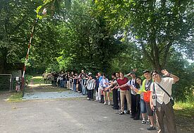 Jugendliche aus drei Ländern pilgern an der deutsch-dänischen Grenze Die Gruppe bildet eine Menschenkette über die deutsch-dänische Grenze.