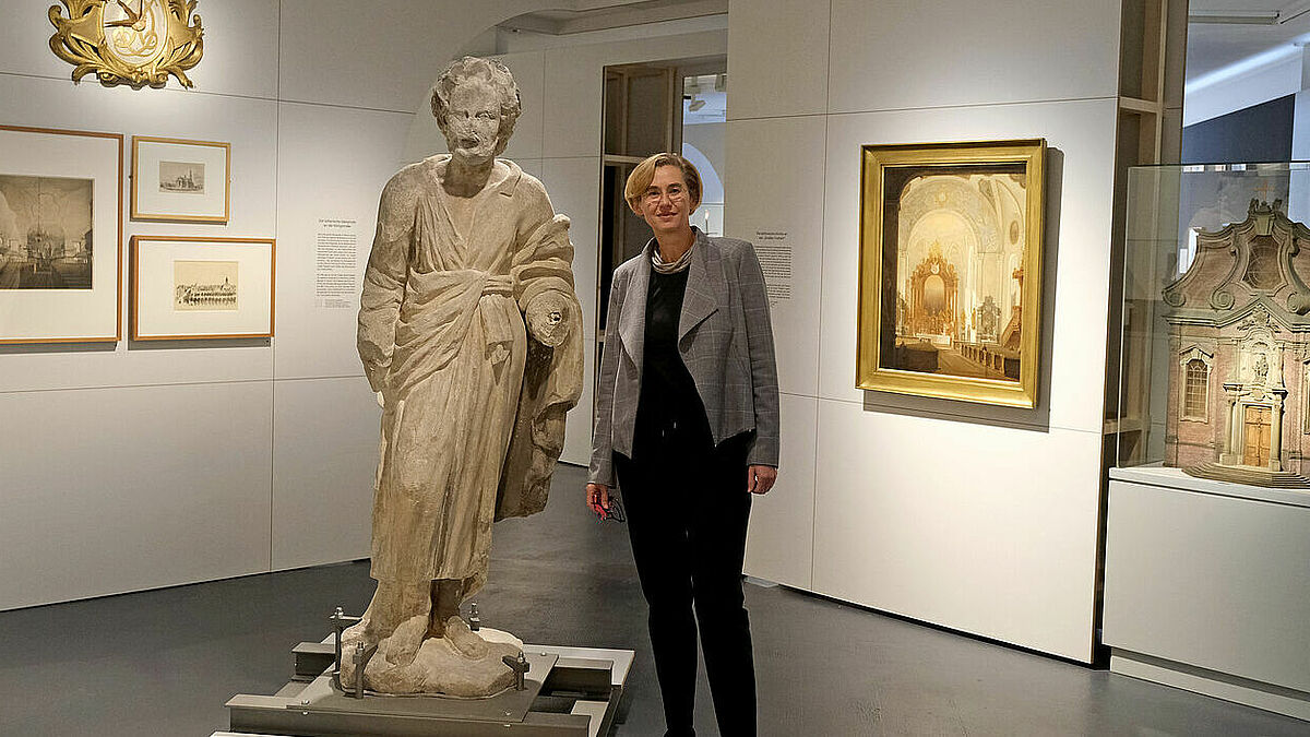 Museumsdirektorin Anja Dauschek in Altona: Links an der Wand hängen Exponate über die lutherische Gemeinde an der Königstrasse. Die Skulptur steht für die katholische Kirche St. Josef (re. Bild und Modell), sie wurde 1723 eingeweiht und steht heute noch an der Großen Freiheit auf St. Pauli mitten im Amüsierviertel.