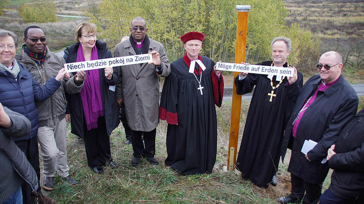 Am "Peace Pole" bei Neu-Rosow: Bischöfin Sarah Bullock, Diözese Lichfield, England, Bschof Dr. Alex Mkumbo (ELCT, Tansania), Landesbischöfin Kühnbaum-Schmidt, Bischof Chediel E. Sendoro, Mwanga Diözese Tansania, Prof. Dr. Marcin Hintz, Bischof Tilman Jeremias, Bischof Waldemar Pytel. Foto: Stefan Döbler, Nordkirche