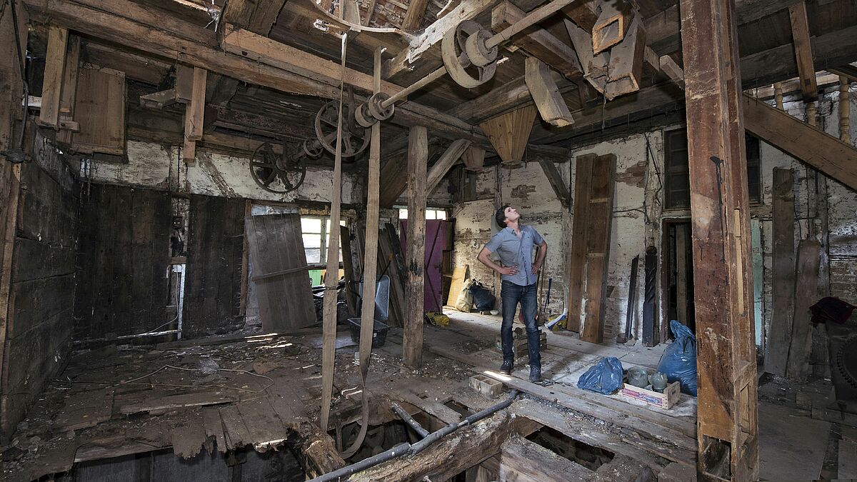 Pastor Christian Bauer im Innenraum der Wassermühle in Roidin 