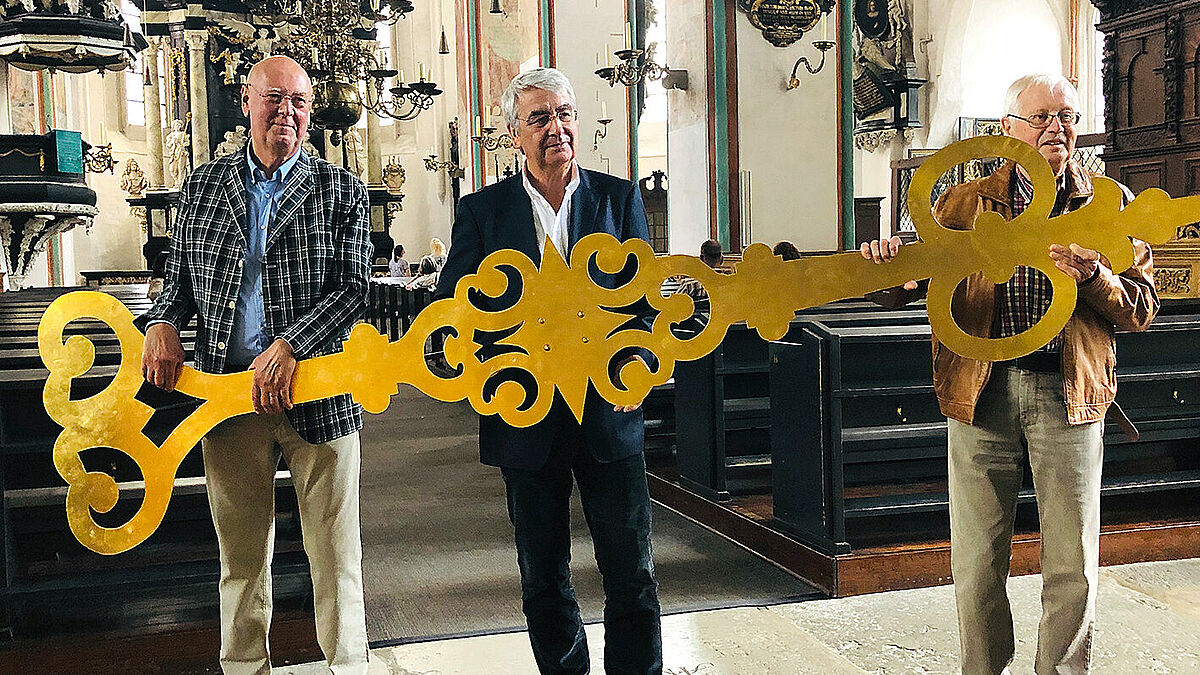 Jo Böcher, Vorsitzender des Fördervereins von St. Jakobi, Pastor Lutz Jedeck und Joachim Glowe, Stellvertretender Vorsitzender des Fördervereins, mit einem der abmontierten Zeiger von St. Jakobi Lübeck.