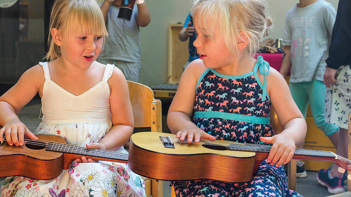 Jana (links) und Johanna probieren sich an der Gitarre.