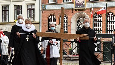 Bischöfin Kirsten Fehrs und Erzbischof Stefan Heße tragen das Kreuz durch Lübecks Altstadt.